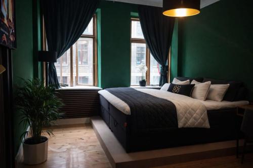 a green bedroom with a bed and a window at Greenbrook - Black Suite in Aalborg