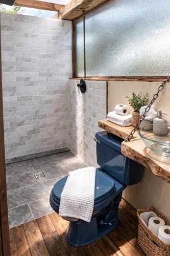 a bathroom with a blue toilet and a sink at La Meca Glamping in Guasca