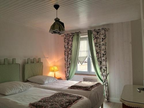 a bedroom with two beds and a window at La p'tite Maison in Vitrac