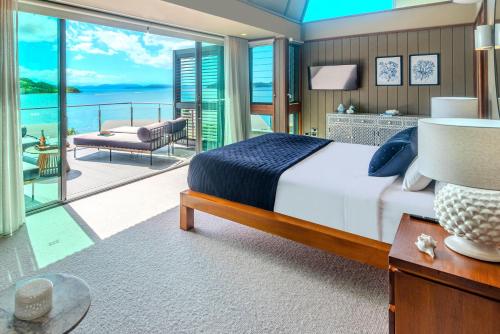 a bedroom with a bed and a view of the ocean at Yacht Club 33 Serenity House Ocean Views 2 Buggies in Hamilton Island