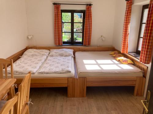 two beds in a room with two windows at Apartment Panteon Basecamp in Malá Skála