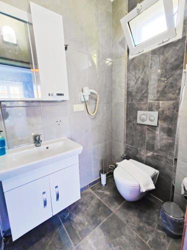 a bathroom with a white sink and a toilet at Mavi Akvaryum Pension in Sogut