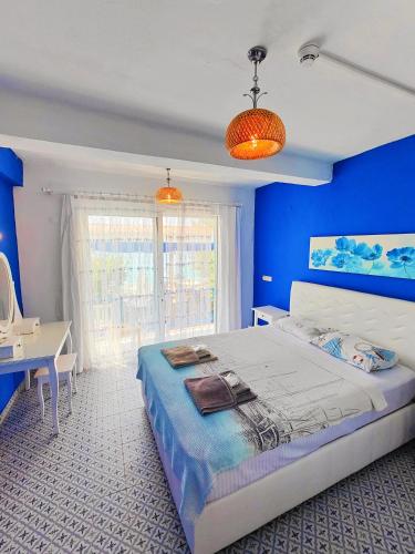 a blue bedroom with a bed and a desk at Mavi Akvaryum Pension in Sogut