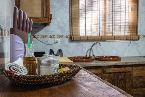 a kitchen with a table with a basket of utensils at La Vaquería in Niebla