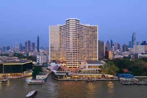 a large building on the side of a river at Royal Orchid Sheraton Riverside Hotel Bangkok in Bangkok