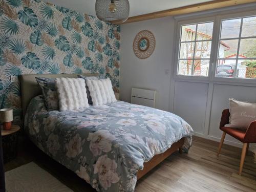 a bedroom with a bed with a floral bedspread at Zalicarté in Saint-Jean-Pied-de-Port