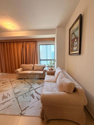 a living room with two couches and a window at Spacious & classic Apartment in center of JBR in Dubai