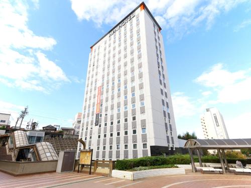 a tall white building with a lot of windows at APA Hotel Keisei Narita Ekimae in Narita