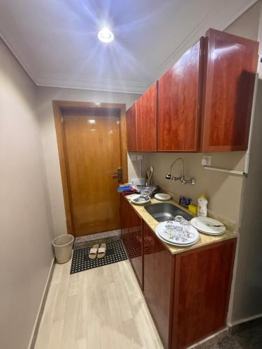 a small kitchen with a sink and wooden cabinets at سحابة صيف للشقق المخدومه 1 - حي النزهه - in Abha