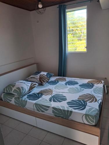 a bed sitting in a room with a window at Simple, discret et fonctionnel in Le Lamentin