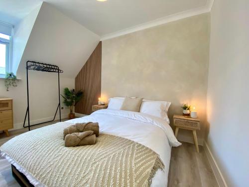a bedroom with a bed with a stuffed animal on it at Luxury Scandi Inspired 1 Bed Apartment in Bournemouth