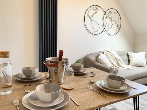 a living room with a wooden table with dishes on it at Luxury Scandi Inspired 1 Bed Apartment in Bournemouth