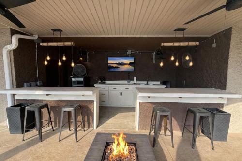 a kitchen with a fireplace and a table and stools at Mimosa Mornings Home for 12 in Rocky Mount