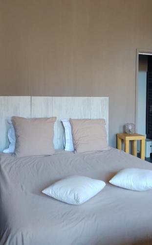 ein großes weißes Bett mit vier Kissen darauf in der Unterkunft Artbnb in Lézat-sur-Lèze