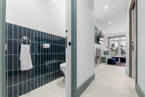 a bathroom with a toilet and blue tiles at Stunning Townhouse - 7 bedrooms - up to 18 Guests in Cardiff