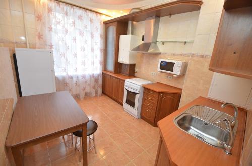 a small kitchen with a sink and a table at Apartment in the center on Spasskaya Street in Mykolaiv