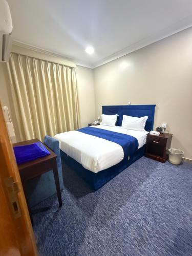 a bedroom with a large bed with a blue headboard at سحابة صيف للشقق المخدومه 1 - حي النزهه - in Abha