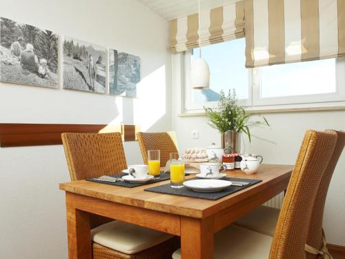 a dining room table with chairs and a wooden table with drinks at Schittlerhaus in Oberstdorf