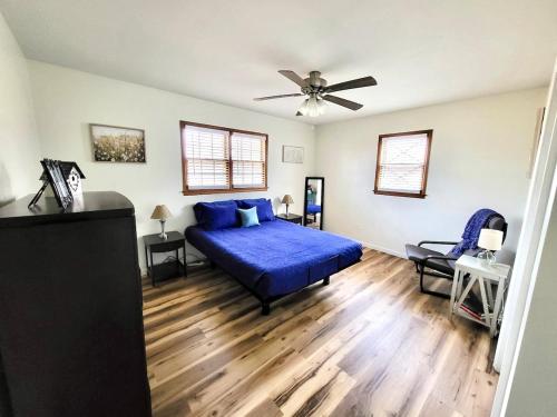 a bedroom with a blue bed and a ceiling fan at The Willowdell Nook in Mulvane