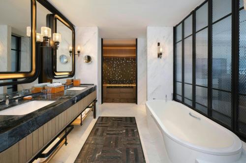a bathroom with two sinks and a bath tub at Sheraton Ningbo Yinzhou in Ningbo