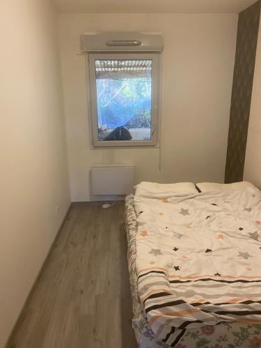 a small bedroom with a bed and a window at Maison de Campagne in Aussonne
