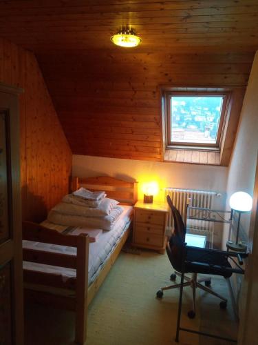 a bedroom with a bed and a desk and a window at Gästezimmer Stadtpark in Biel