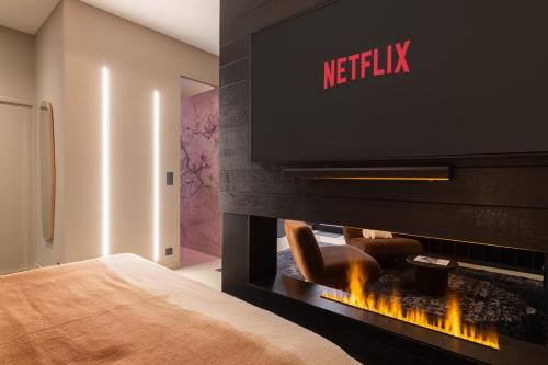 a bedroom with a television above a fireplace at Host Inn Velvy Suite in Lyon