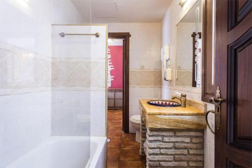 a bathroom with a tub and a sink and a toilet at Arte Vida Suites & Spa in Granada