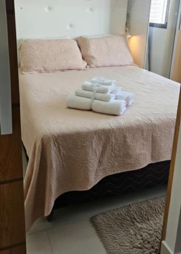 two towels are stacked on a bed in a room at Apê Panoramic Águas Claras e Ministérios in Brasília