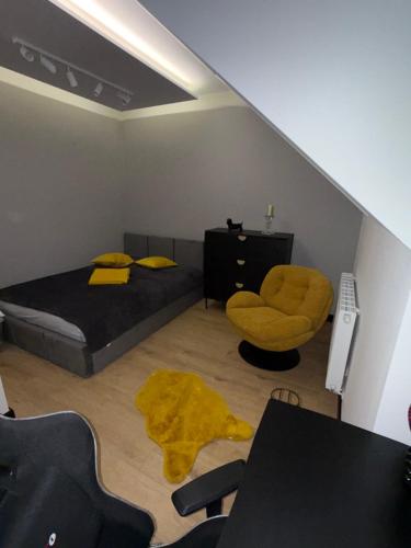 a bedroom with a bed and a chair and a desk at S Golf Apartament in Gowinko