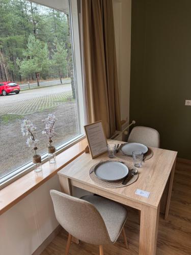 a wooden table with two chairs and a window at Boslust in Bergen op Zoom