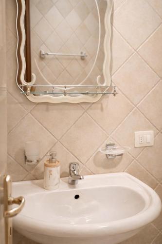 a bathroom with a sink and a mirror on the wall at Hana's Apartment in Durrës