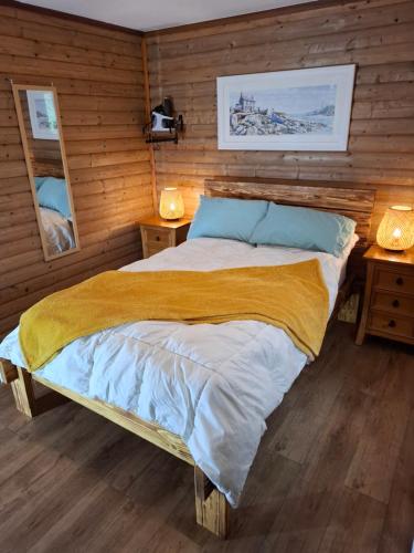 a large bed in a room with wooden walls at The Swallow's Return LogCabin, Carlingford, A91D954 in Carlingford