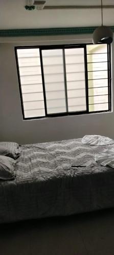 a bedroom with a bed and a large window at La Pradera in Pereira