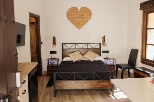 a bedroom with a bed with a heart on the wall at La Posada del Diezmo in Manzanilla