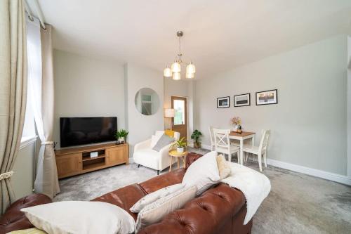 a living room with a couch and a television at Robins Nest Cottage in Blairgowrie