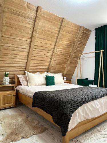 a bedroom with a large bed with a wooden headboard at Dream Cottage in Paltin