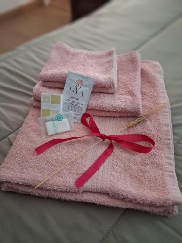 a pink towel with a red ribbon on a bed at Il Doganiere in Montecchio