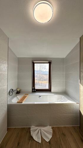 a large white tub in a bathroom with a window at Dream Cottage in Paltin