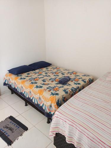 a bedroom with a bed with a comforter on it at Casa mobiliada 2 Com 4 camas e 2 quartos com ar condicionado in Juazeiro do Norte