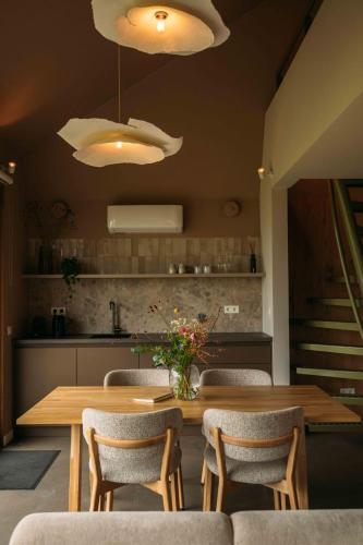 a dining room with a wooden table and chairs at Gastenverblijf Buitenhoudt in Vinkel