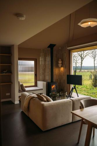 a living room with a couch and a fireplace at Gastenverblijf Buitenhoudt in Vinkel