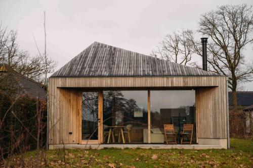 a small wooden house with a table and chairs at Gastenverblijf Buitenhoudt in Vinkel