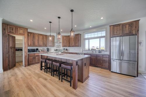 a kitchen with wooden cabinets and a large island with bar chairs at 3 King Beds Spacious 4 BR 3 BATH AC Near Jackson in Victor