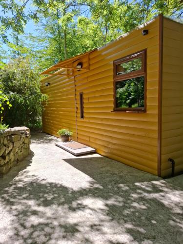a small yellow building with a window on it at The Swallow's Return LogCabin, Carlingford, A91D954 in Carlingford