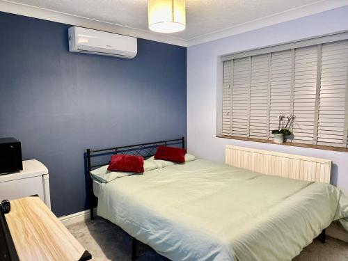 a bedroom with a bed with two red pillows on it at 40 Kennett gardens in Gloucester