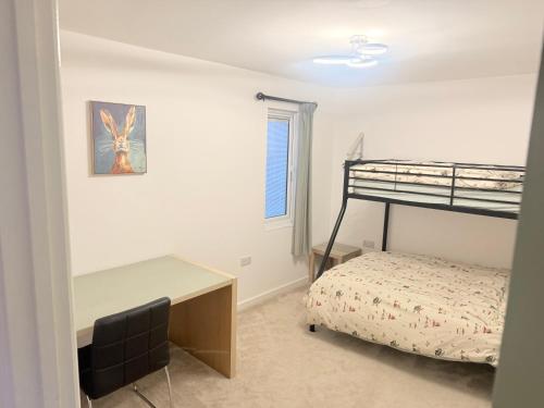 a bedroom with a desk and a bunk bed at Poplar holiday cottage in Moulton Chapel