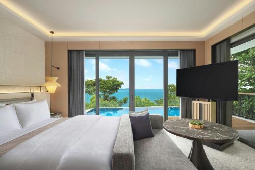 a bedroom with a large bed and a tv at The Westin Nirup Island Resort & Spa in Belakangpandang