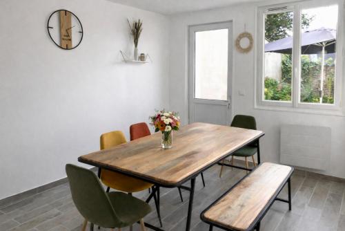 a dining room with a wooden table and chairs at La Coloc Boho - Saint-Quentin, chambres centre, idéal pro in Saint-Quentin