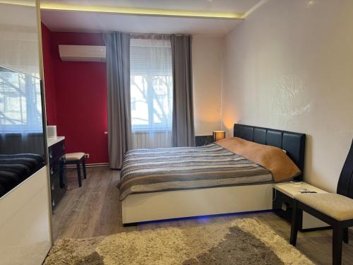 a bedroom with a bed and a desk and a window at Apartamento Elit in Dimitrovgrad